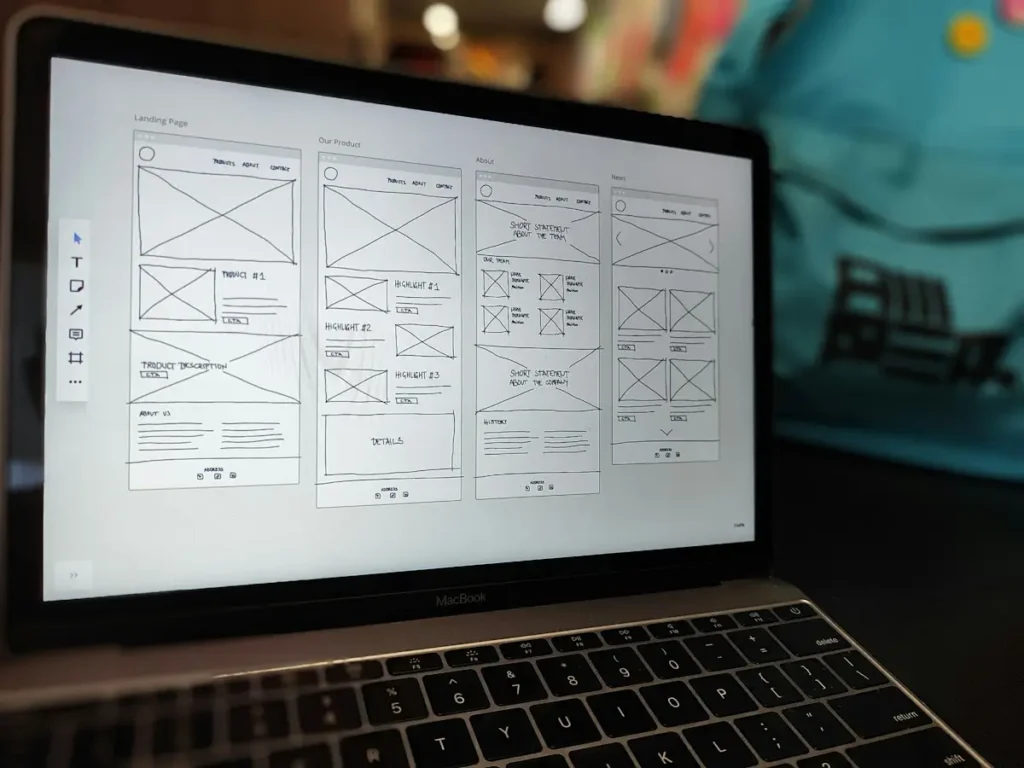 Website wireframe open on a laptop on a designer's desk